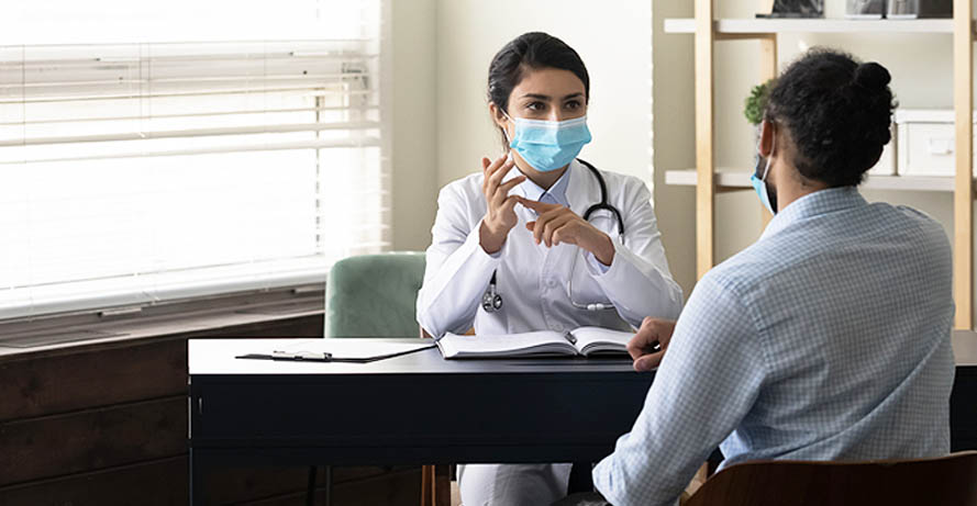 a doctor sitting at her desk consulting with a patient