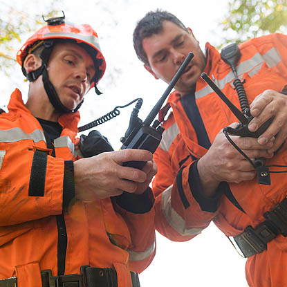 two responders checking their two-way radios